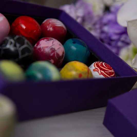 Colorful chocolate in a purple box with flowers in the background