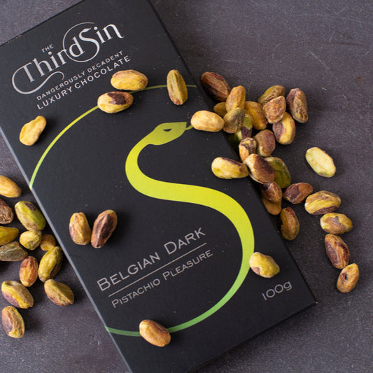 Third Sin Belgian Dark Pistachio Pleasure chocolate bar with pistachios on a dark surface