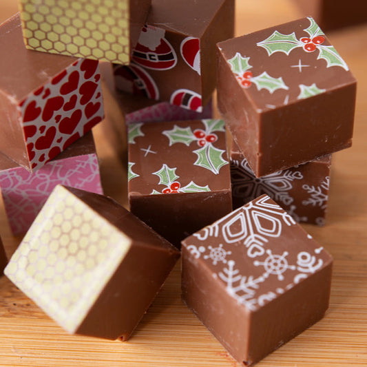 Decorative chocolate cubes with various patterns on a wooden surface
