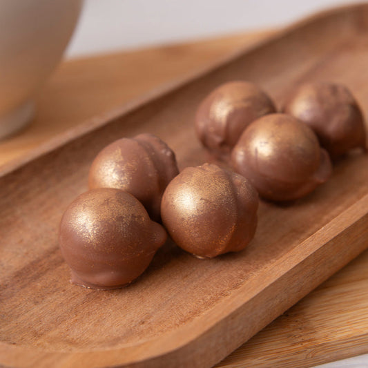 Chocolate truffles on a wooden tray with a blurred background
