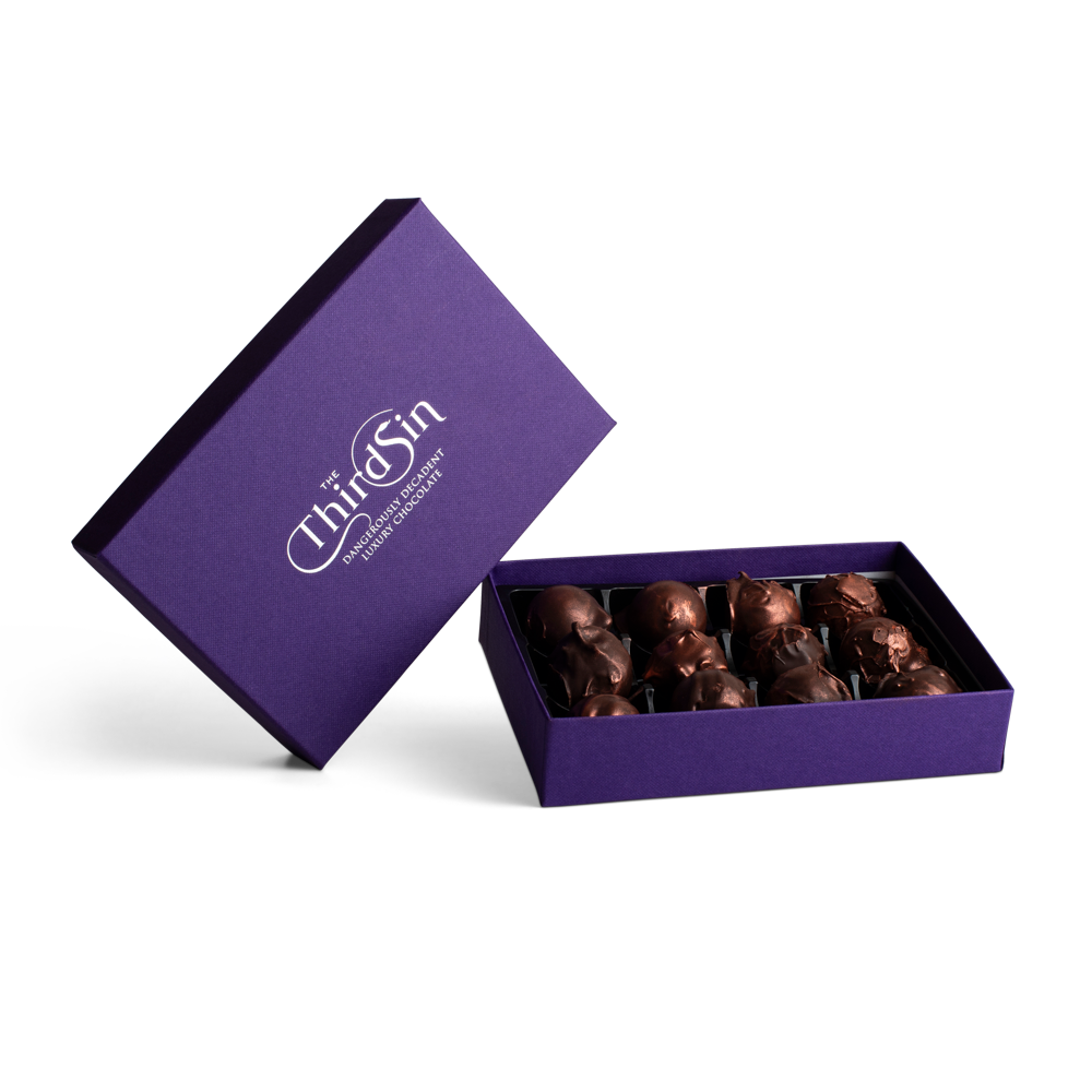 Open purple box with chocolates and 'The Third Sin' branding on a white background