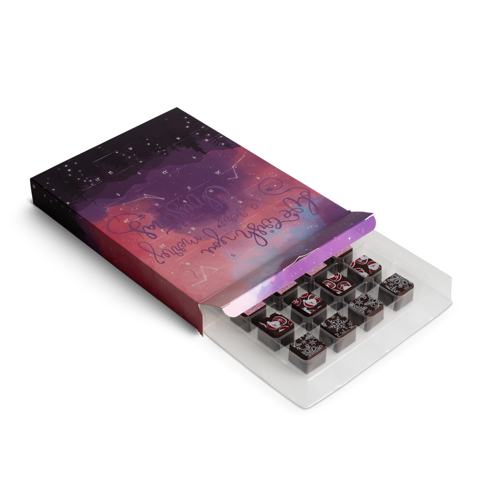 Advent calendar box open Set of small square chocolates in a clear plastic tray with a decorative box on a white background