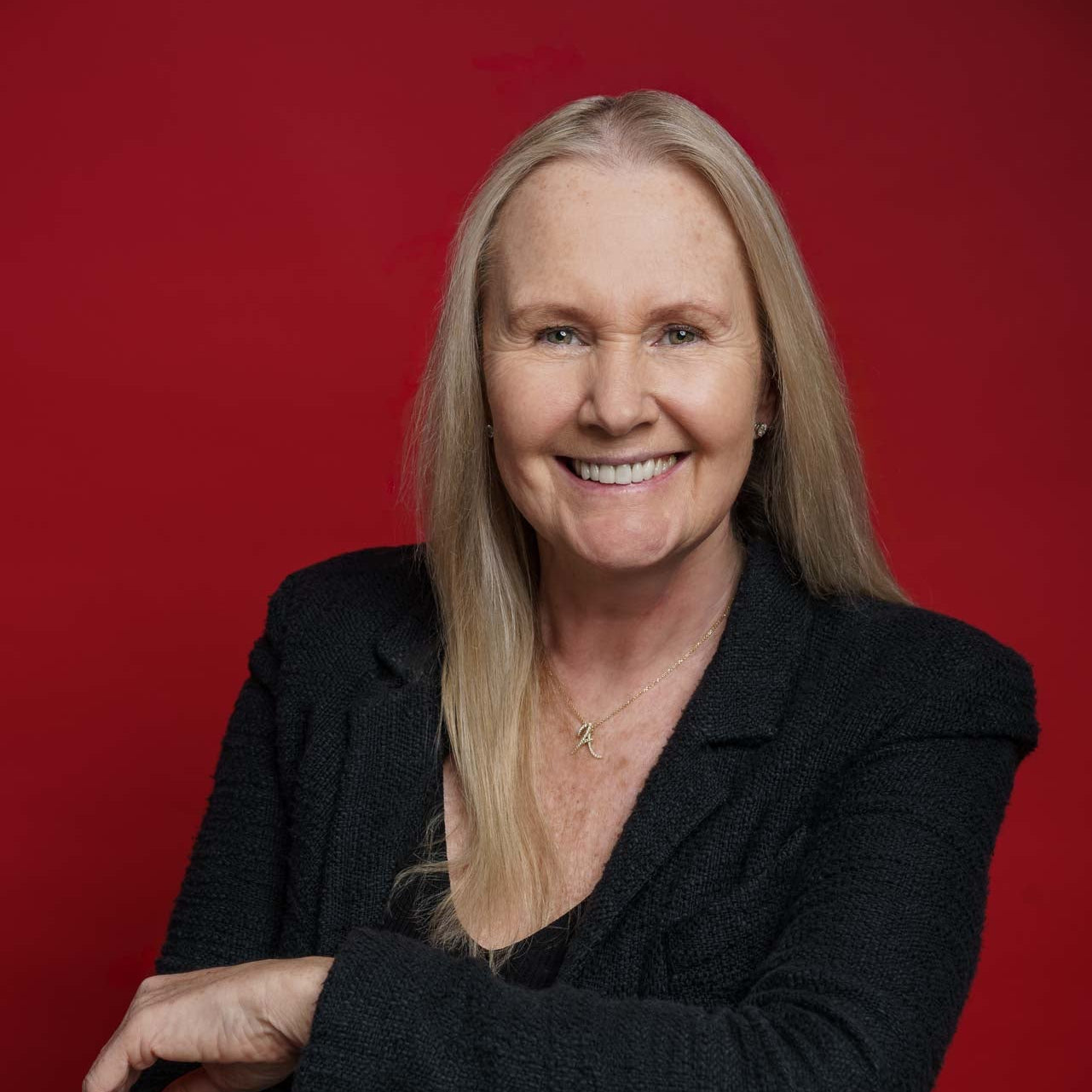 Woman sitting on a chair against a red background