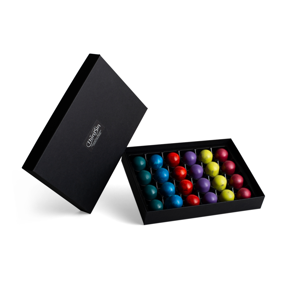 Black box with colorful chocolates on a white background