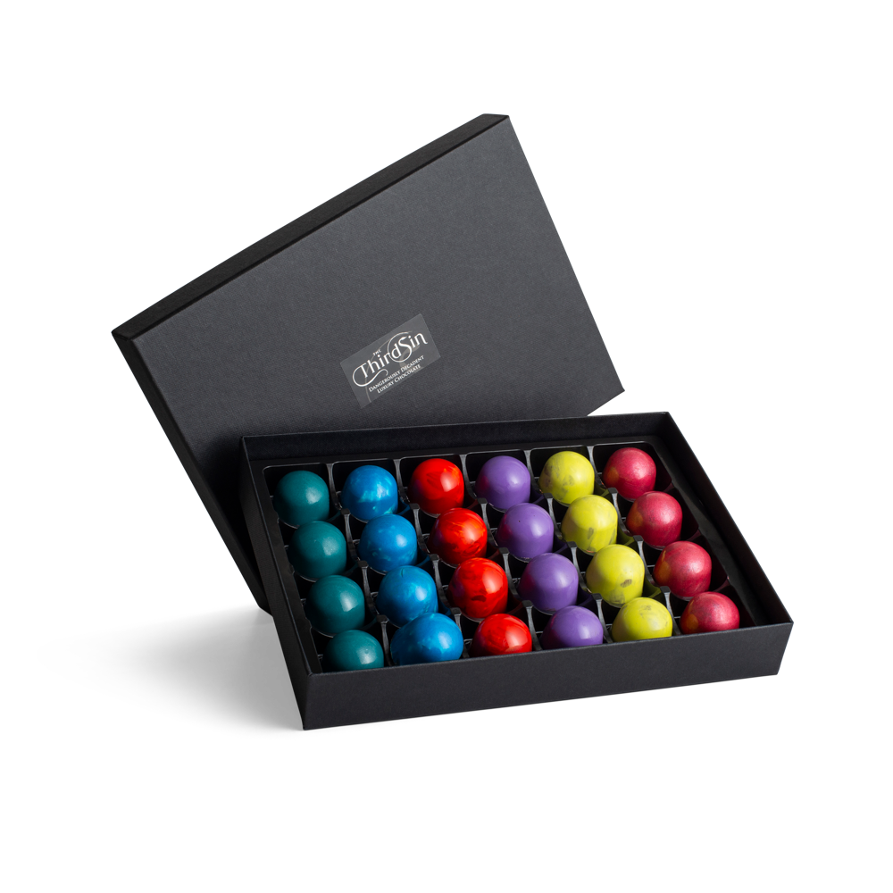 Black box with colourful chocolates on a white background