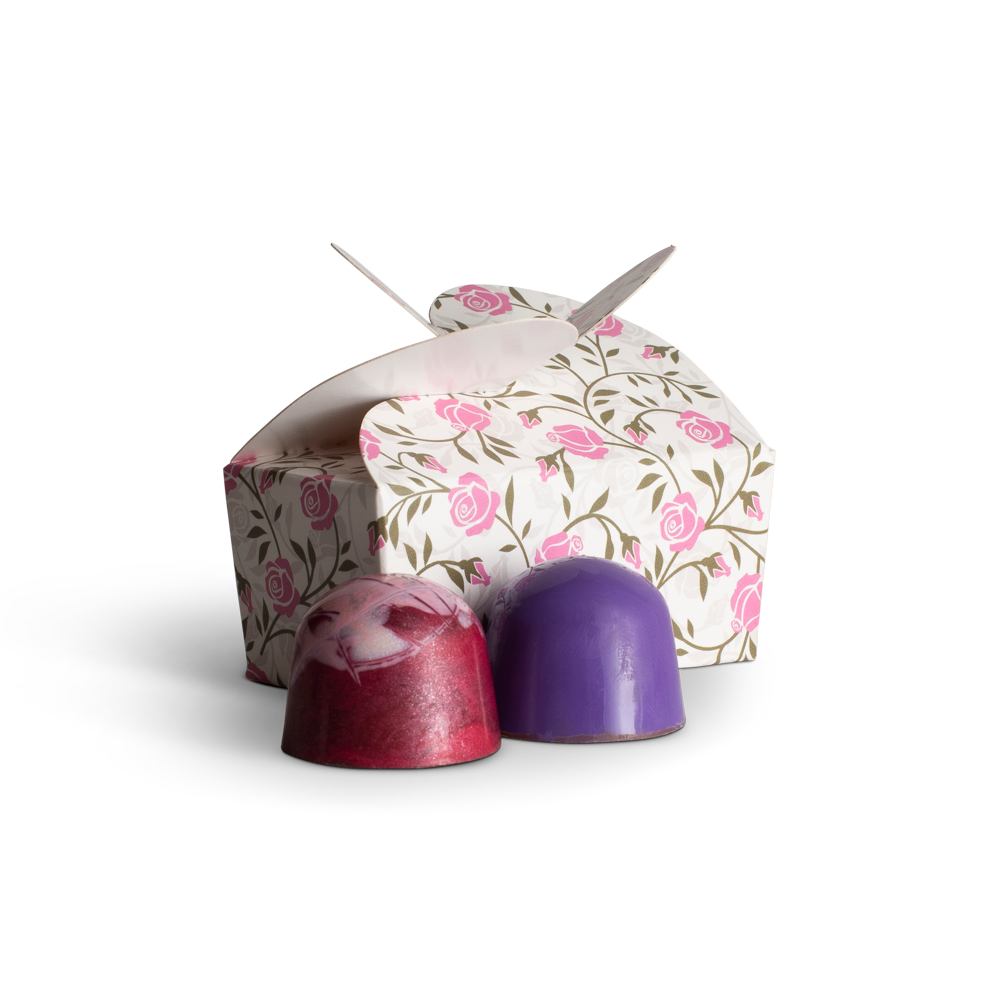 Decorative choclate wedding favours with floral design and purple accents on a white background